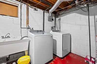 a bathroom with two washing machines and a sink at Beautiful home, a few minutes to the waterfall and attractions in Niagara Falls