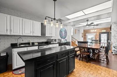 a kitchen with a black counter top and a table at Beautiful home, a few minutes to the waterfall and attractions in Niagara Falls