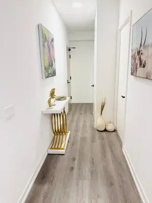a hallway with white walls and wood floors at Bright & Cozy 1 Bedroom Retreat in Vaughan