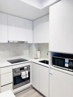 a white kitchen with white cabinets and appliances at Bright & Cozy 1 Bedroom Retreat in Vaughan