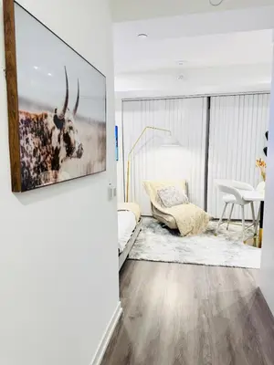 a living room with a picture of a cow on the wall at Bright & Cozy 1 Bedroom Retreat in Vaughan