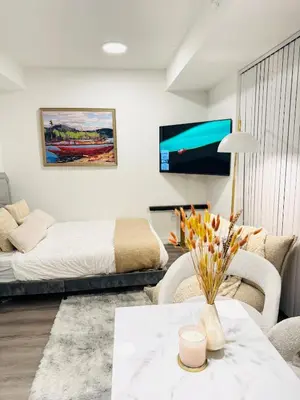 a living room with a bed and a table at Bright & Cozy 1 Bedroom Retreat in Vaughan