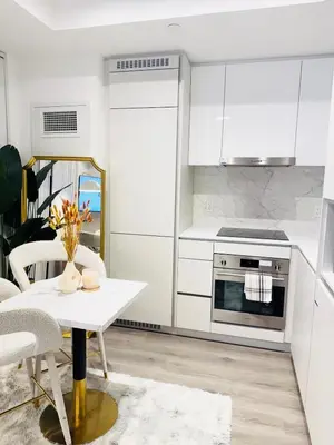 a kitchen with white cabinets and a white table at Bright & Cozy 1 Bedroom Retreat in Vaughan