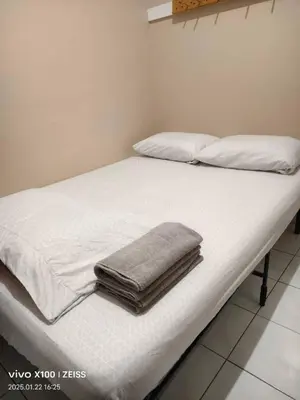 a bed with white sheets and a towel on it at Toronto Travellers Home in Toronto