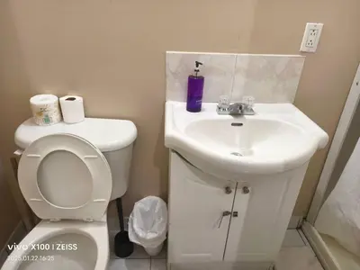 a bathroom with a white toilet and a sink at Toronto Travellers Home in Toronto