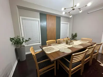 a dining room with a wooden table and chairs at Luxurious Villa 3 Living Rooms, 1 sofa bed, 4 bedrooms, 4 Beds, 4 Toilets, 1 hour To Toronto in Oshawa