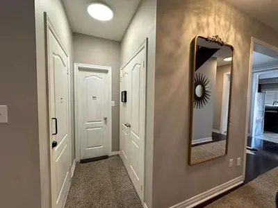 a hallway with a mirror on the wall at Luxurious Villa 3 Living Rooms, 1 sofa bed, 4 bedrooms, 4 Beds, 4 Toilets, 1 hour To Toronto in Oshawa