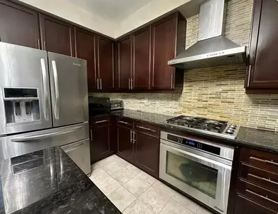 a kitchen with wooden cabinets and stainless steel appliances at Luxurious Villa 3 Living Rooms, 1 sofa bed, 4 bedrooms, 4 Beds, 4 Toilets, 1 hour To Toronto in Oshawa