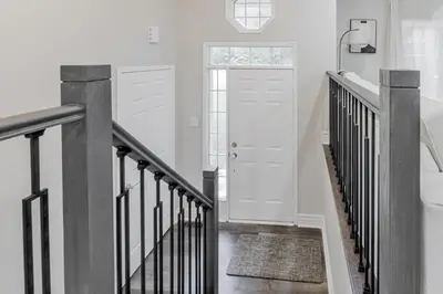 a white hallway with a staircase with a white door at Innisfil retreat, hot tub, Sauna, EV plug, Generac in Innisfil