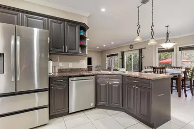 a kitchen with dark brown cabinets and a kitchen island at Home in Richmond Hill in Richmond Hill