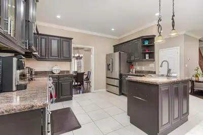 a large kitchen with black cabinets and a kitchen island at Home in Richmond Hill in Richmond Hill