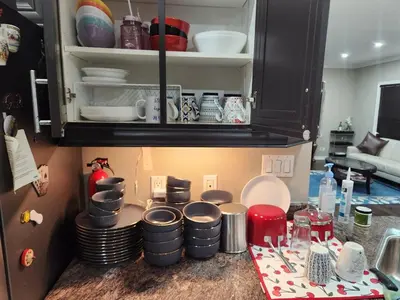 a kitchen counter with plates and dishes in a cabinet at Home in Richmond Hill in Richmond Hill
