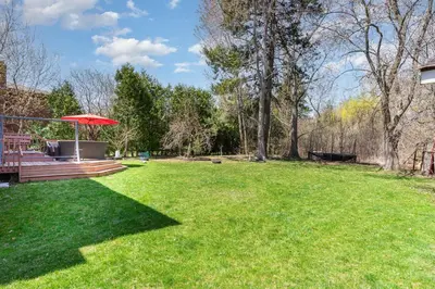 a yard with a bench and an umbrella in the grass at Home in Richmond Hill in Richmond Hill