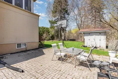 a patio with a table and chairs and a basketball hoop at Home in Richmond Hill in Richmond Hill
