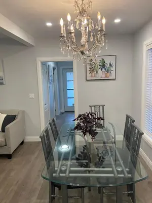 a glass dining room table with chairs and a chandelier at Rock place in Niagara Falls