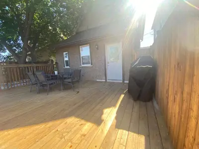 a wooden deck with a table and chairs on it at Rock place in Niagara Falls