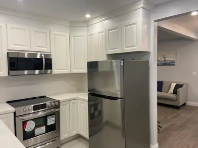 a kitchen with white cabinets and a stainless steel refrigerator at Rock place in Niagara Falls