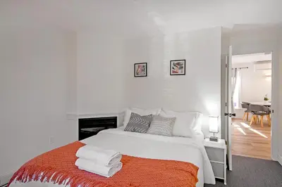 a white bedroom with a bed with towels on it at The Willow Suite Near DT & Hospital in Peterborough