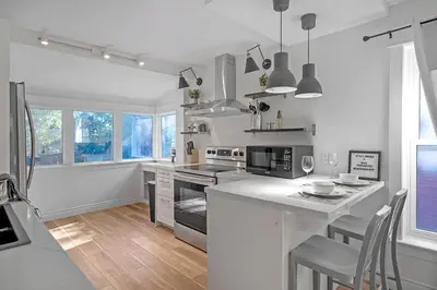 a white kitchen with a counter and a table at The Willow Suite Near DT & Hospital in Peterborough