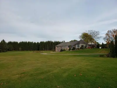 a large house in a field with a large yard at Summer Escape Close to the City in Newmarket