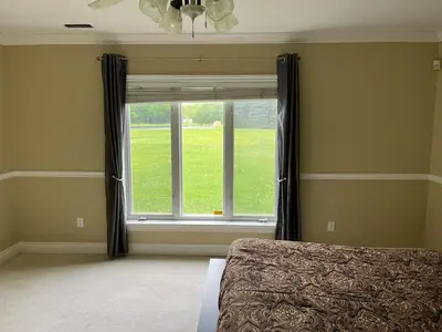 a bedroom with a bed and a large window at Summer Escape Close to the City in Newmarket