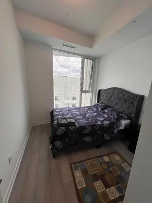 a bedroom with a bed and a large window at Vaughan Cozy 1 Bedroom Condo in Vaughan