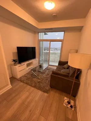 a living room with a couch and a flat screen tv at Vaughan Cozy 1 Bedroom Condo in Vaughan