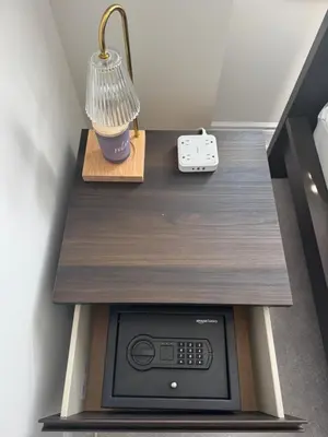 a table with a lamp and a remote control on it at Vellore's Ritz and Rest House in Vaughan