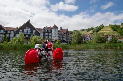 a group of people riding on a paddle board in the water at Blue Mountain Resort Village Suites in Blue Mountains