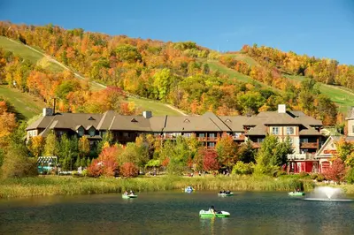 people in canoes on a lake in front of a resort at Blue Mountain Resort Village Suites in Blue Mountains