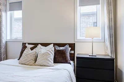a bedroom with a bed and two windows at Richland Modern Luxury house in Richmond Hill