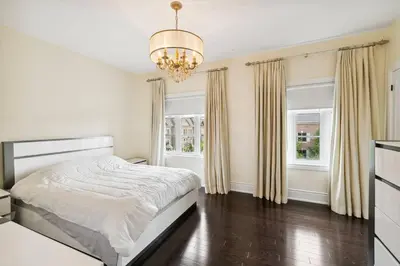 a white bedroom with a bed and a chandelier at Quiet Getaway Perfect for Families and Retreats in Mississauga