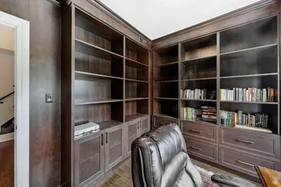 a leather chair in a library with book shelves at Quiet Getaway Perfect for Families and Retreats in Mississauga