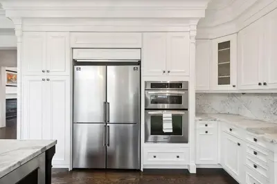 a kitchen with a stainless steel refrigerator and white cabinets at Quiet Getaway Perfect for Families and Retreats in Mississauga