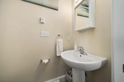 a white bathroom with a sink and a mirror at The Catbird - 28 Butternut in Cherry Valley