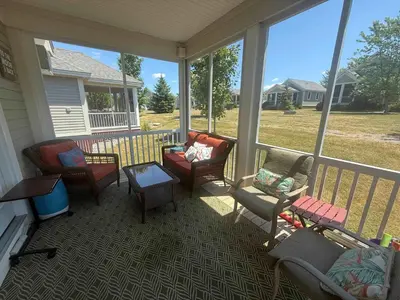 a screened in porch with chairs and a table at The Catbird - 28 Butternut in Cherry Valley