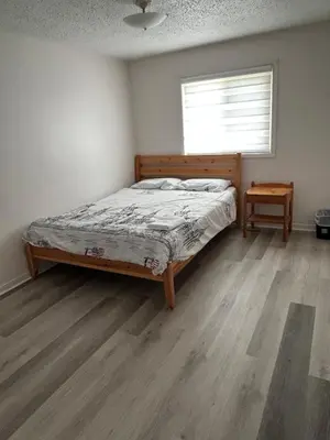 a bedroom with a bed and a window and a wooden floor at Cozy Ajax Stay for Families in Ajax