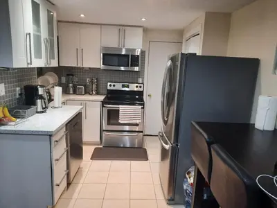 a kitchen with a stainless steel refrigerator and appliances at Cozy Two-Bedroom Luxury Suite near Toronto Airport in Mississauga