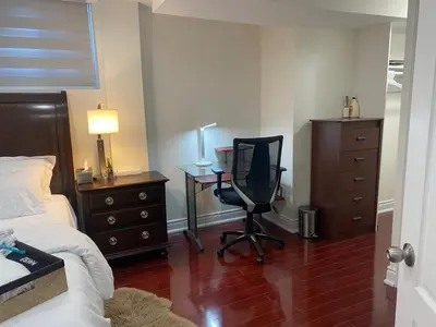 a bedroom with a bed and a desk and a chair at Cozy Two-Bedroom Luxury Suite near Toronto Airport in Mississauga