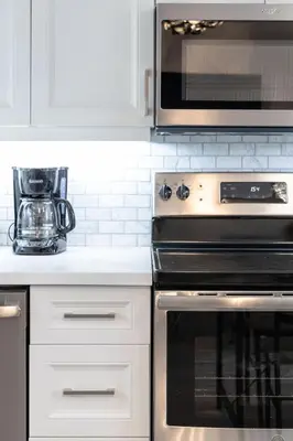 a kitchen with a stove and a microwave at The Bloor Spadina Getaway With 3-Bedroom and Private Patio in Toronto