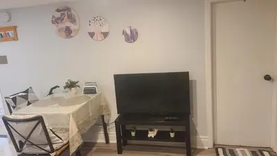 a living room with a table with a flat screen tv at 132 Chatham ave in Toronto