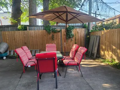 a table with red chairs and an umbrella at 132 Chatham ave in Toronto