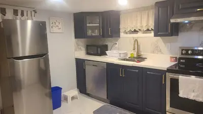 a kitchen with black cabinets and a stainless steel refrigerator at 132 Chatham ave in Toronto