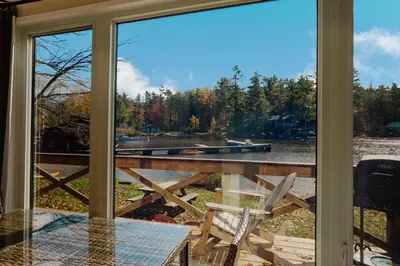 a screened in porch with a table and a chair at 2-Bedroom Cottage #10 - Pitch Pine in Gravenhurst