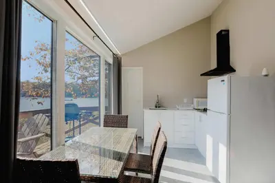 a kitchen with a glass table and a refrigerator at 2-Bedroom Cottage #10 - Pitch Pine in Gravenhurst