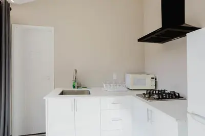 a white kitchen with a sink and a microwave at 2-Bedroom Cottage #10 - Pitch Pine in Gravenhurst