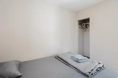 a bed in a white room with a blanket at 2-Bedroom Cottage #10 - Pitch Pine in Gravenhurst