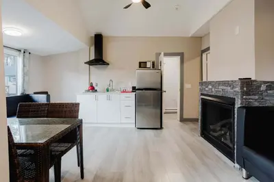 a living room with a fireplace and a refrigerator at 3-Bedroom Cottage #7 - Austrian Pine in Gravenhurst