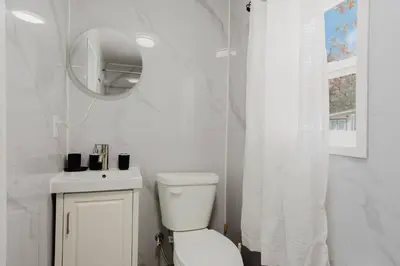 a white bathroom with a toilet and a mirror at 3-Bedroom Cottage #7 - Austrian Pine in Gravenhurst