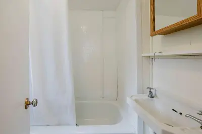a white bathroom with a shower and a sink at 2-Bedroom Cottage #5 - Lodgepole Pine in Gravenhurst